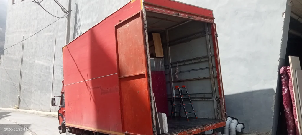 Trabzon Yomra evden eve nakliyat hizmeti kırmızı kapalı kasa nakliye kamyonla yükleme yapılırken bir kare