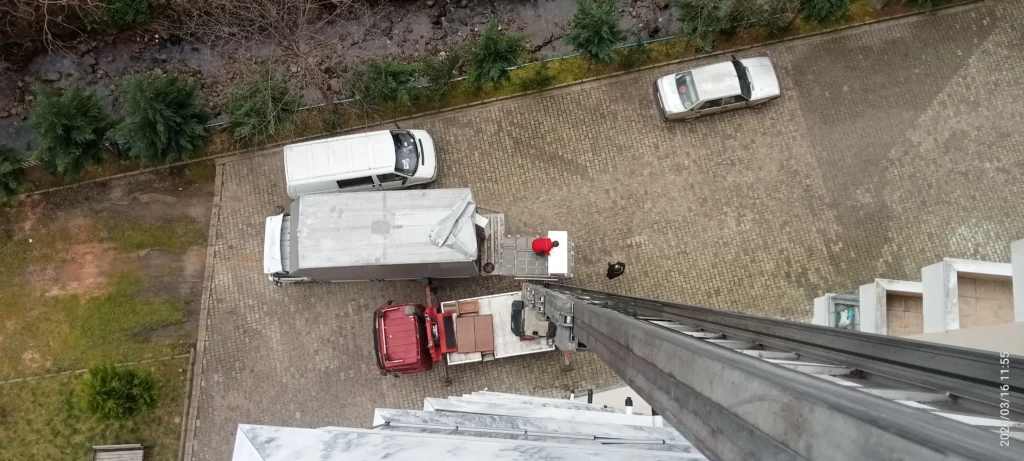Trabzon Araklı asansörlü evden eve nakliyatı anlatan görselin fotoğraf karesi kamyon ve asansörün balkondan görünüşü.